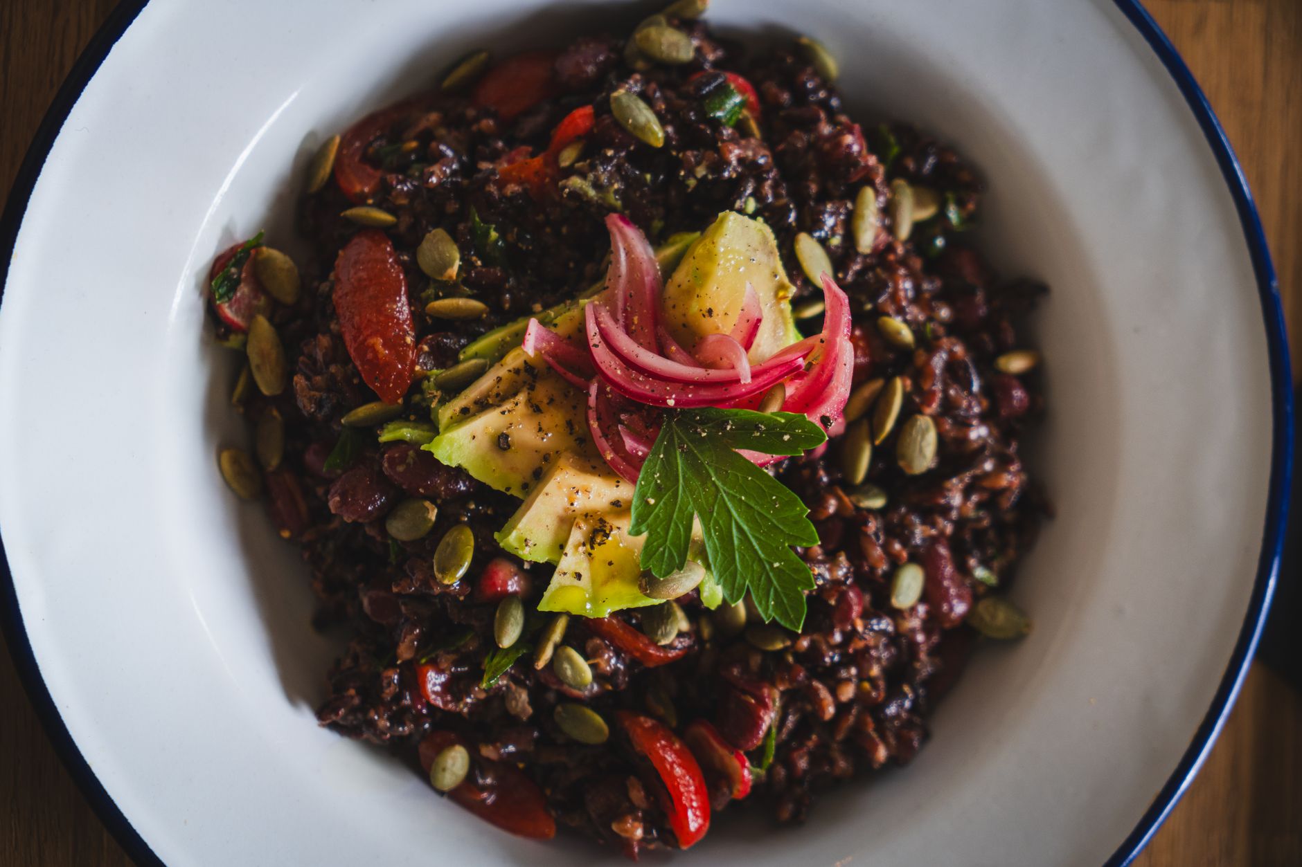 Healthy vegan black rice salad topped with avocado, pickled onions, and pumpkin seeds. — American Steakhouse in Sydney: Enjoy